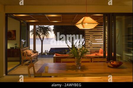 Cette maison lumineuse et moderne dispose d'une salle à manger intérieure ouverte sur le patio avec vue sur l'océan Banque D'Images