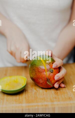 Femme Coupant Des Fruits Mango Avec Sharp Knife Banque D'Images