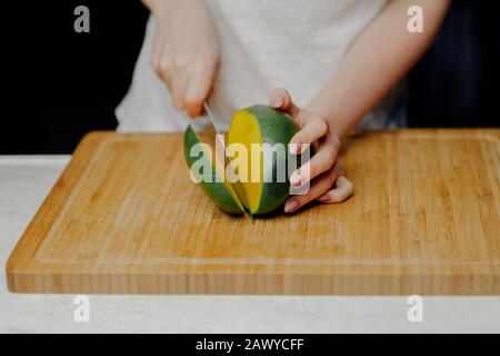 Femme Coupant Des Fruits Mango Avec Sharp Knife Banque D'Images