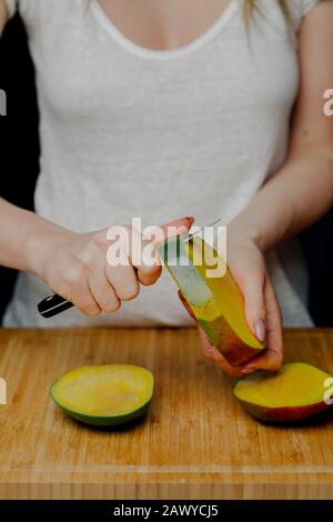 Femme Coupant Des Fruits Mango Avec Sharp Knife Banque D'Images