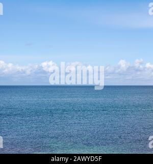 Nuages formant dans le ciel bleu sur un horizon marin Banque D'Images