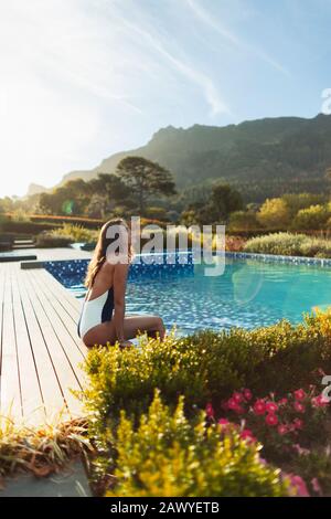 Une femme sereine dans un maillot de bain relaxant dans une piscine idyllique et tranquille, le Cap, Afrique du Sud Banque D'Images