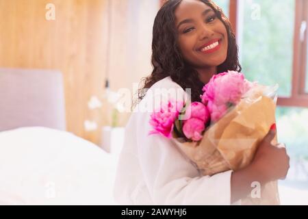 Portrait heureuse jeune femme avec bouquet de fleurs roses de pivoine Banque D'Images