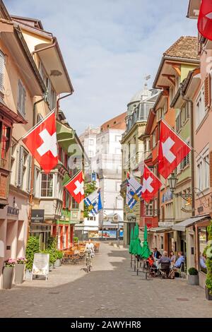 Zurich, Suisse - 10 juin 2017 : rue Augustinergasse à Zuerich, quartier Lindenhof avec drapeaux suisses. Banque D'Images