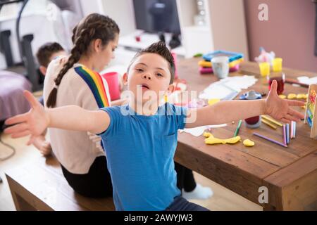 Portrait joueur garçon avec Le syndrome De Down jouant à la table de salle à manger Banque D'Images