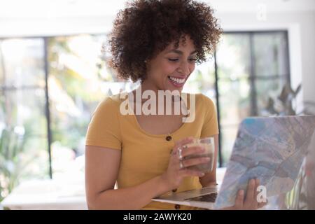 Bonne jeune femme indépendante travaillant sur un ordinateur portable Banque D'Images
