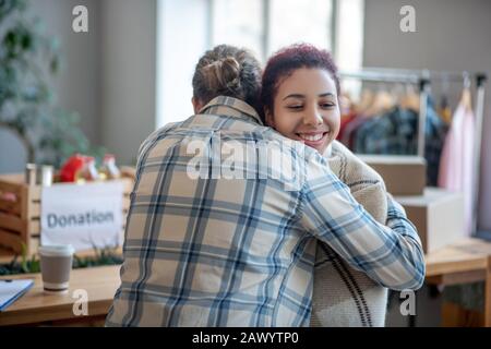 Homme en chemise de plaid embrassant jeune fille souriante. Banque D'Images