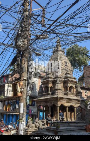 Patan, Népal - 24 janvier 2020: Une multitude de câbles électriques suspendus dans la rue de Patan près de Katmandou au Népal Banque D'Images