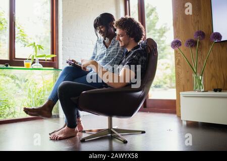 Jeune couple utilisant une tablette numérique dans le bureau à domicile Banque D'Images