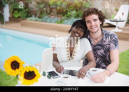 Portrait heureux jeune couple multiethnique au bord de la piscine Banque D'Images