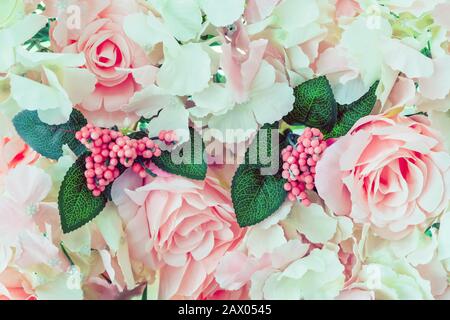De nombreuses roses artificielles roses et blanches sont décorées sur la porte en verre à la toile de fond dans l'après-midi. Fleurs magnifiques arrière-plan, foyer sélectif. Banque D'Images