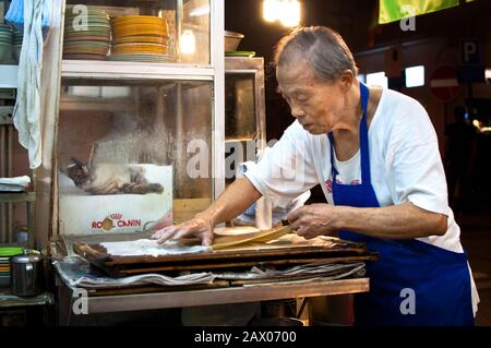 Hong Kong homme faisant des rouleaux de riz vapeur traditionnels (cheung fen) dans un congee shop dans le quartier de Tai Hang sur l'île de Hong Kong Banque D'Images