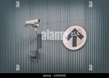 Caméra de surveillance avec panneau de direction vintage des États-Unis sur un mur en acier Banque D'Images