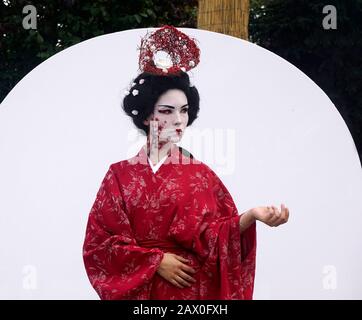 Timisoara, Roumanie- 09.06.2019 statue vivante d'une geisha japonaise. Une femme vêtue de kimono pose comme une statue humaine réaliste dans un parc. Banque D'Images