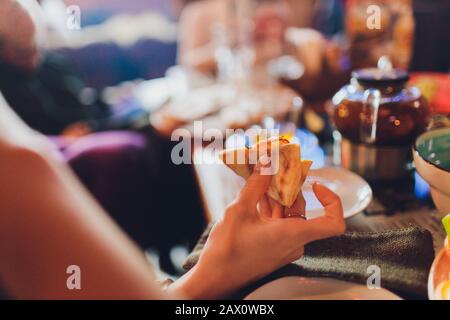 Gros plan main de femme tenant, prendre tranche, morceau de pizza de la boîte, amis assis ensemble dans le café, passer du temps libre, manger italien Fast-food, e Banque D'Images