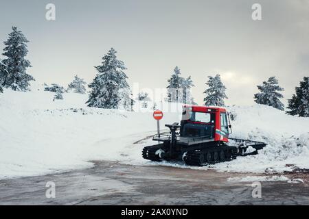 Stocker la photo d'un chasse-neige après le travail au milieu d'un endroit enneigé et un signal interdit de passer Banque D'Images