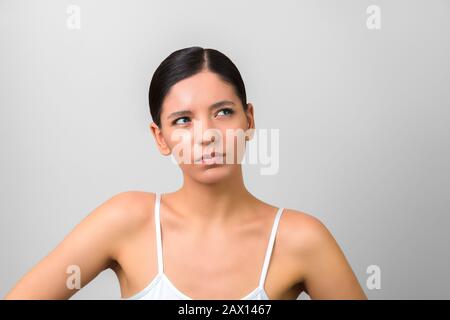 suis-je beau. femme de beauté pensant et recherchant isolé sur fond gris Banque D'Images