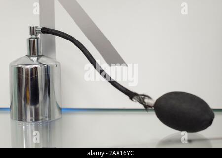 bouteille en métal sur une étagère grise et blanche. Vieux parfum. Collection de parfums anciens, bijoux de coiffeur. Poire usée Banque D'Images