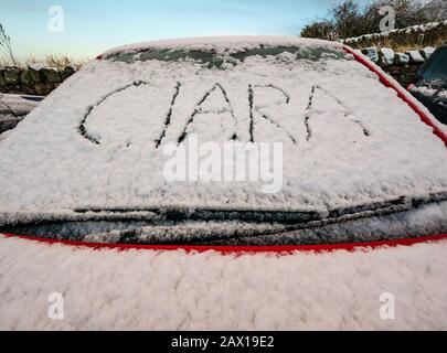 East Lothian, Écosse, Royaume-Uni. 10 février 2020. Météo au Royaume-Uni : Storm Ciara apporte la première neige de l'hiver dans la partie orientale du pays. Le pare-brise d'une voiture rouge est recouvert de neige avec le mot Ciara rayé dans la neige Banque D'Images