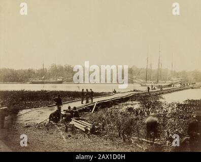 1864, POTOMAC , États-Unis : pont Pontoon traversant la rivière James à Powhatan point sur lequel l'armée de Potomac a traversé, juin 1864 . Photo de JAMES GARDNER - SÉCESSION WAR CIVIL - GUERRA CIVILE DI SECESSIONE AMERICANA - STATI UNITI AMERICA - truppe - militari - troupes militaires - SOLDATS DE L'UNION - USA - NORDISTA - NORDISTI - TRUPPE NORDISTE - panorama - Ponte di barche - fiume - nef - Navi - veliero - velieri --- Archivio GBB Banque D'Images