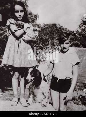 1939 CA : L'actrice ELIZABETH TAYLOR ( Londres , Angleterre 1932 ) quand était un enfant avec le frère de ses HOWARD , Whit leurs animaux de compagnie - CINÉMA - portrait - ritratto - fratello - fratelli - frères - soeur - animali domestici - chien - canne - gatto - chat - cocker - enfants - enfant - bambini - bambini - bambina - personalità da giovane giovani - personnalité quand était Jeune - jardin - giardino -- --- Archivio GBB Banque D'Images