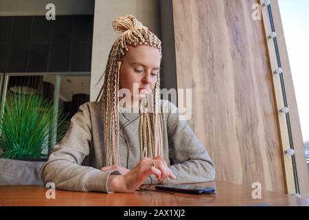 Une jeune femme inquiète dans le café. Concept de latitude ou de ponctualité. Banque D'Images