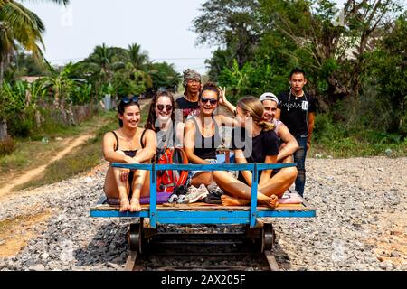 Un Groupe De Jeunes Voyageurs Qui Se Rendent Sur Le Chemin De Fer Bamboo (Norry) , Battambang, Cambodge. Banque D'Images