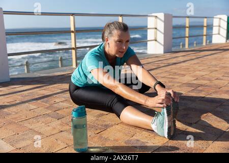 Jogging féminin s'étendant sur le bord de mer Banque D'Images