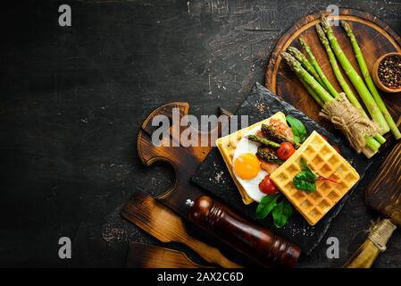 Petit Déjeuner. Gaufres belges avec œufs, asperges et bacon. Des aliments sains. Vue de dessus. Espace libre pour votre texte. Banque D'Images