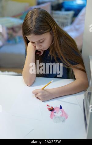 la jeune fille s'est focalisée sur le dessin à la maison Banque D'Images