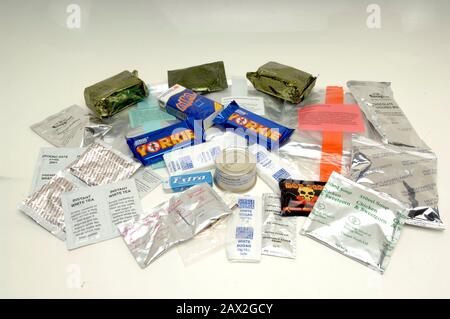 Un sac de ration de 24 heures est remis aux soldats qui servent en Afghanistan en 2005. Les paquets de haute calorie sont des problèmes standard pour les forces armées britanniques lors des opérations et, selon lui, contiennent suffisamment de nourriture pour durer une personne 24 heures.Flocons D'Avoine, biscuits, tissus, bar yorkie, bonbons aromatisés aux fruits, ragoût d'agneau aux pommes de terre, saucisses de poulet et haricots dans la sauce tomate, boulettes De Fruits dans la crème anglaise, Jus d'orange sec, poudre de café, gomme de soup.chewing de poulet et de maïs sucré, pate de poulet et d'herbes, sauce au poivre chaud, boisson végétale. Blanchiment de boissons, poudre à boire aromatisée au chocolat, thé instantané. Banque D'Images