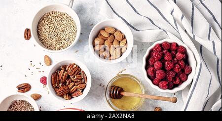 Ingrédients pour un petit déjeuner sain, flocons d'avoine avec framboises, figues, pépins, amandes, graines de lin, graines de chia avec miel et café. Bonjour, guérir Banque D'Images