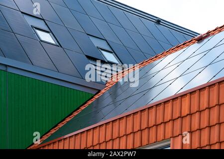 Capteurs solaires sur une maison revêtue de bois et de bardeaux de toit Banque D'Images