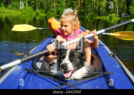 Une fille avec un chien assis dans un kayak sur le lac Banque D'Images