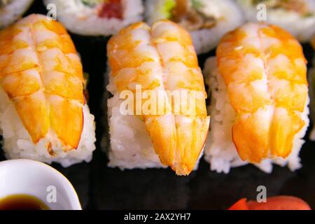 Petits pains et coquelicots avec saumon, crevettes, avocat, concombre, algues sur plaque noire. Banque D'Images