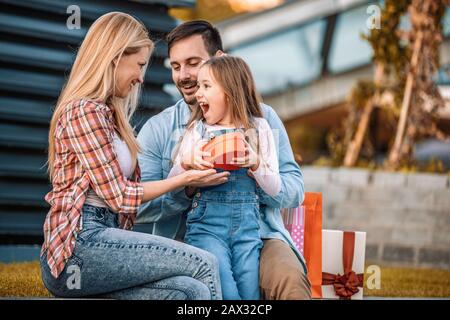 Achats en famille.Les gens Heureux appréciant dans leur temps libre.Les Parents et leur petite fille tiennent des sacs de shopping.Portrait de famille heureuse avec sho Banque D'Images