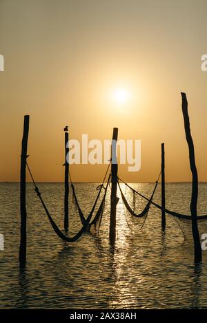 Détendez-vous dans un hamac au-dessus de l'eau au coucher du soleil, Isla Holbox, Mexique Banque D'Images