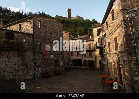 Les rues anciennes de Radicofani avec l'imposant château de Fortness de Cassero dominant dominalement le hameau toscan Toscane Italie Banque D'Images