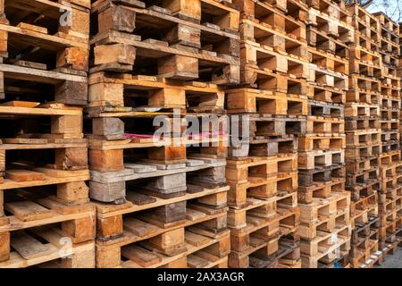 De nombreuses piles de palettes en bois d'occasion de type euro en entrepôt sont prêtes à être recyclées. Contexte industriel. Gros plan. À L'Extérieur. Banque D'Images