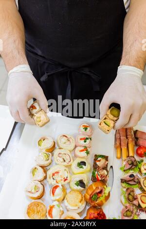 Chef préparant des aliments pour les doigts sur la plaque en papier pour la livraison. Banque D'Images