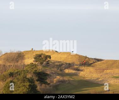 Panorama de collines ondulantes avec randonneurs sous ciel nuageux Banque D'Images