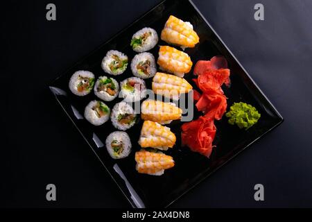 Petits pains et coquelicots avec saumon, crevettes, avocat, concombre, algues sur plaque noire. Banque D'Images