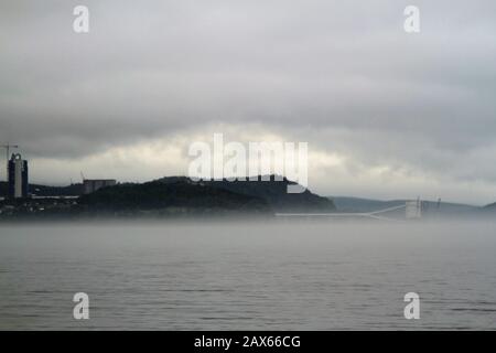 Brume et brouillard qui s'élèvent au-dessus du lac avec des montagnes en arrière-plan Banque D'Images