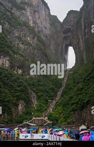 Zhangjiajie, Chine - Août 2019 : foules de touristes Massives attendant dans la pluie torrentielle mousson pour les mini-bus de transport public au pied de Tianmen M Banque D'Images