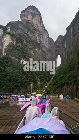 Zhangjiajie, Chine - Août 2019 : foules de touristes Massives attendant dans la pluie torrentielle mousson pour les mini-bus de transport public au pied de Tianmen M Banque D'Images