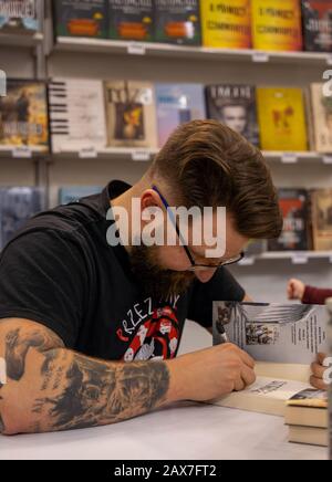 Katowice, Pologne - 6-8 décembre 2019 : Jakub Cwiek, écrivain polonais signe des livres lors de la Foire du livre Silésie à Katowice en 2019 au Congrès international Banque D'Images