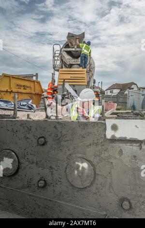 Batteur en béton et ouvrier qui borde une piscine, Saltdean Lido, East Sussex, Royaume-Uni Banque D'Images