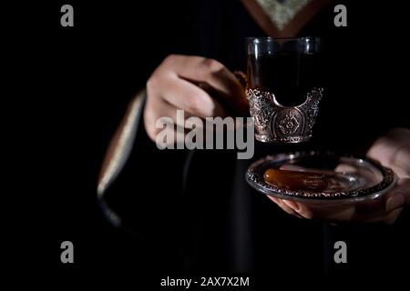 Une femme arabe tenant le gawa (café arabe). Banque D'Images