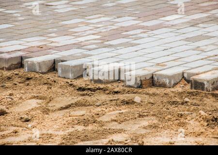 Pose de dalles de pavage sur du sable, réparation et construction dans la rue Banque D'Images