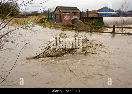 Storm ciara, River irwell éclate ses banques avec des bâtiments industriels en arrière-plan à radcliffe bury lancashire royaume-uni Banque D'Images